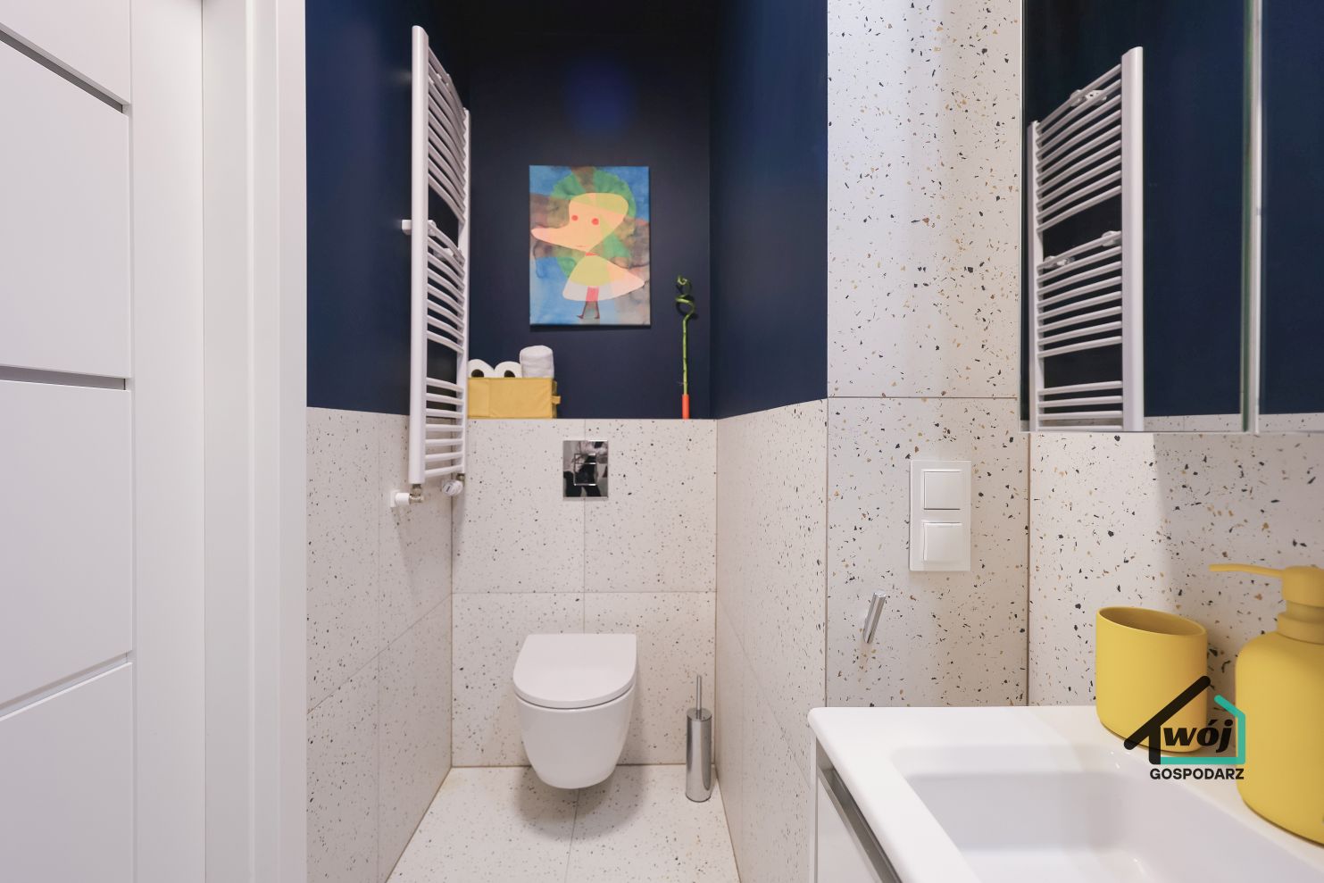 Jasna łazienka apartamentu City Vibe Łódź z toaletą, lustrem i umywalką